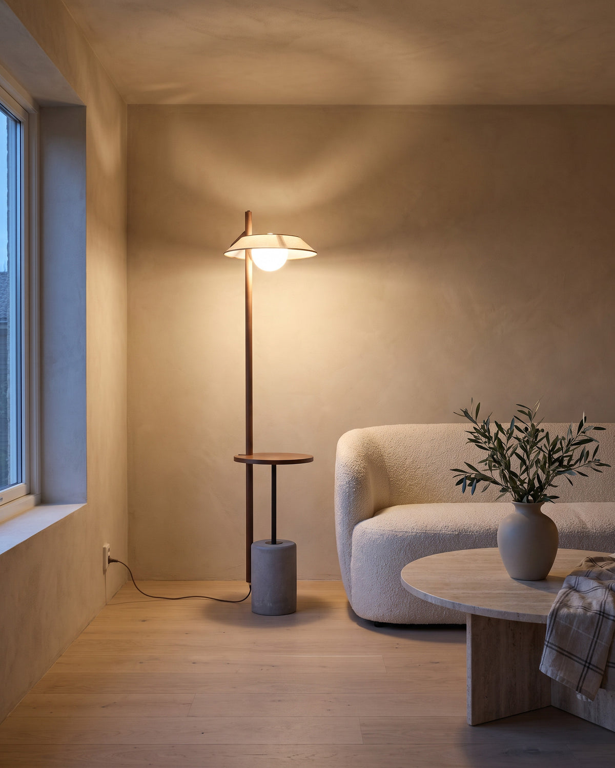 Lampadaire Halte (tige en bois et tablette ronde) dans une pièce, allumé en soirée