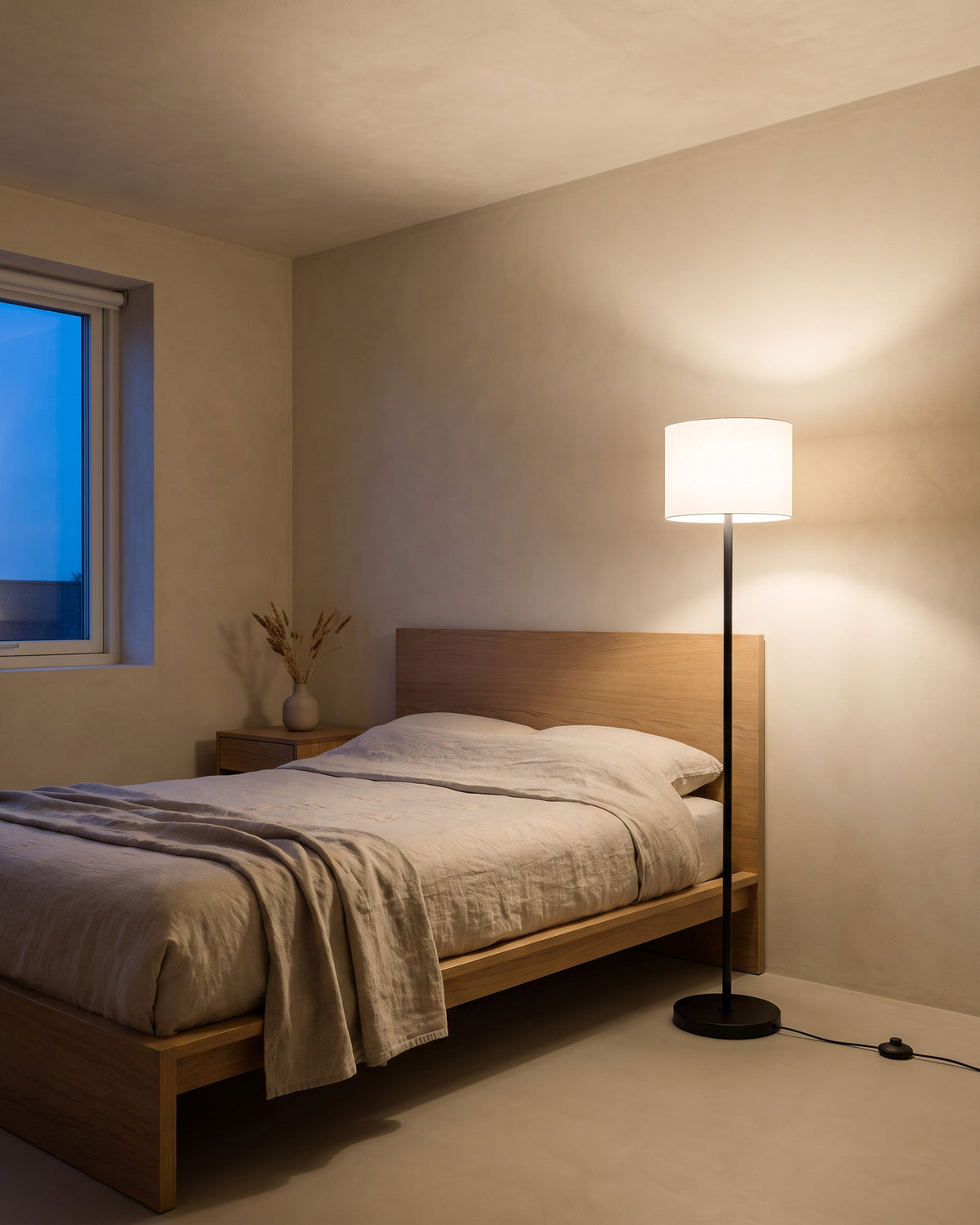 Lampadaire Pilier (tube en tissu blanc et pédale) dans une pièce, allumé en soirée