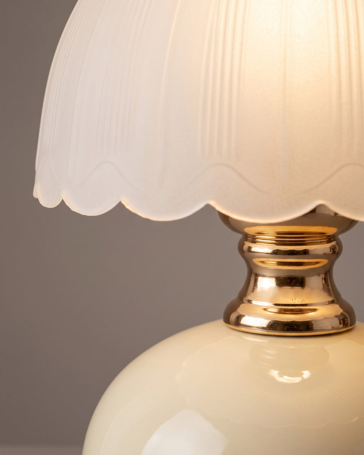 Lampe de table Camomille : gros plan sur le bord festonné du dôme en verre dépoli et la bague dorée