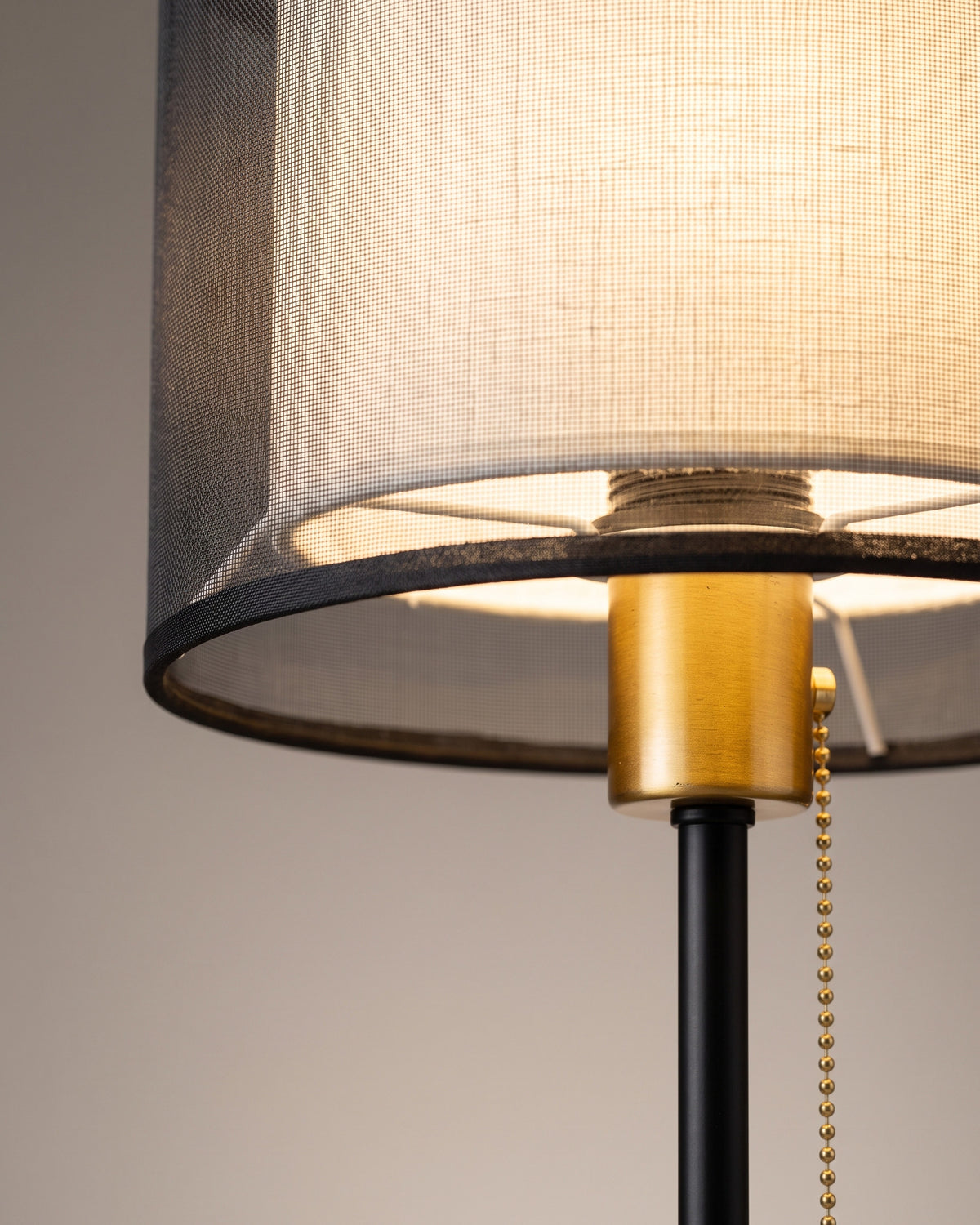 Lampe de table Gaze : gros plan sur le double abat-jour en voile noir et lin blanc avec la bague dorée