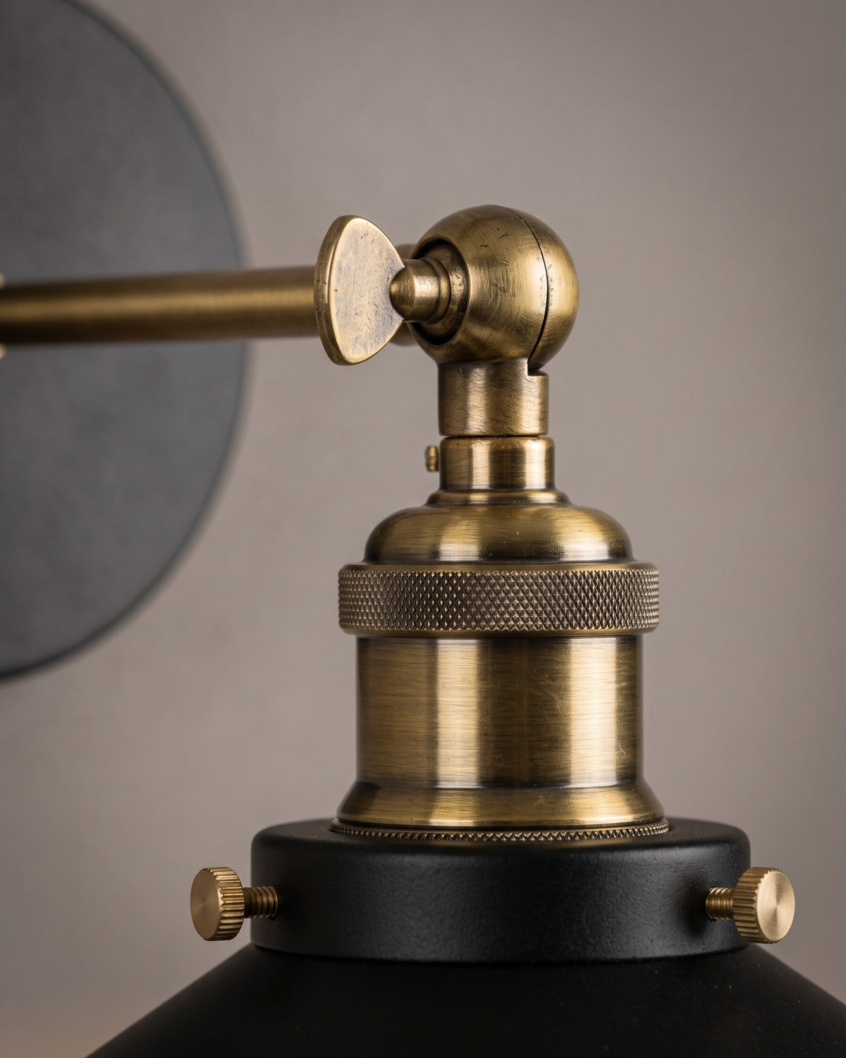 Applique Manufacture : gros plan sur la rotule et la douille moletée dorée au-dessus de l'abat-jour