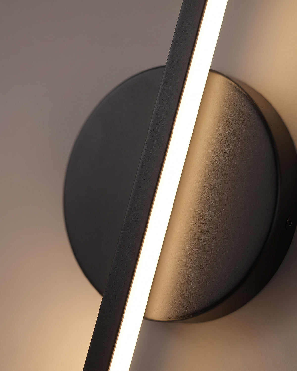 Applique Gnomon : gros plan sur la matière (barre et disque en métal noir, led)