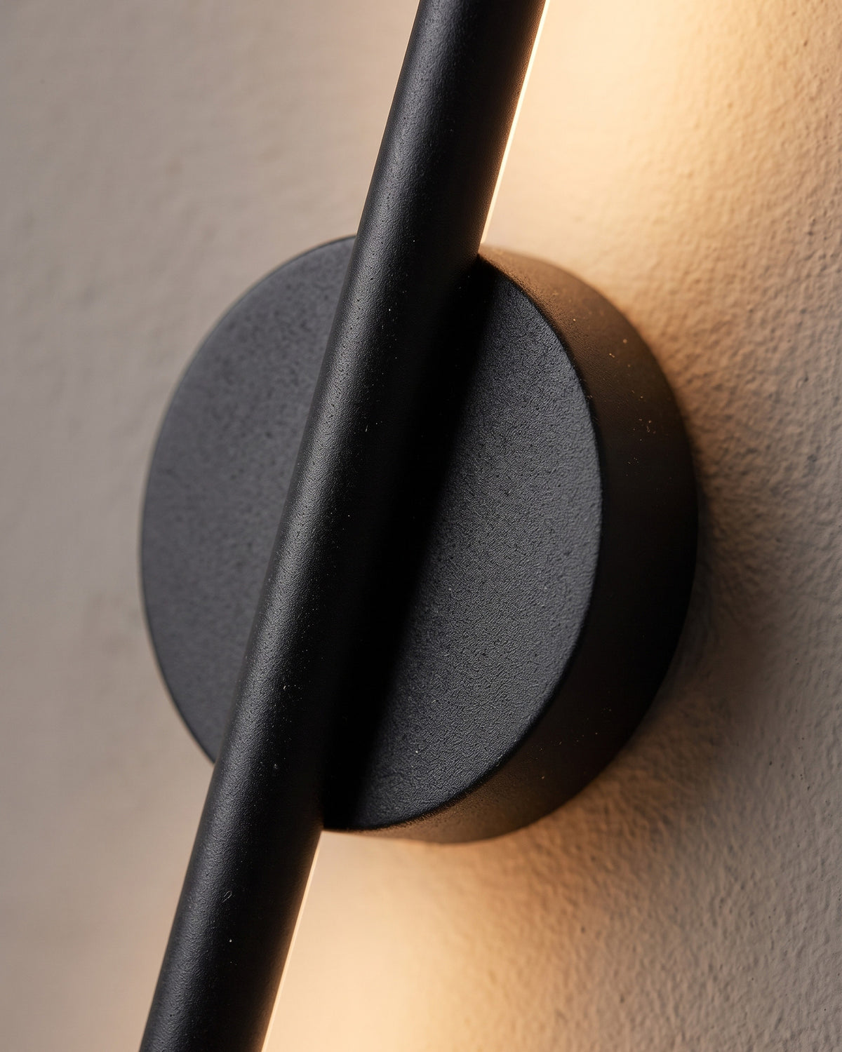 Applique Fil : gros plan sur le disque rond noir et le passage de la tige lumineuse
