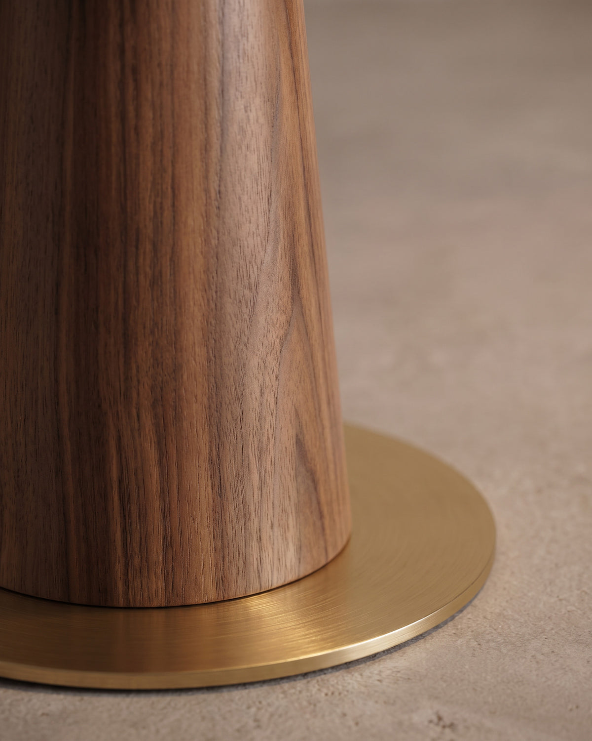 Lampadaire Arche : gros plan sur le pied à finition noyer et le disque doré