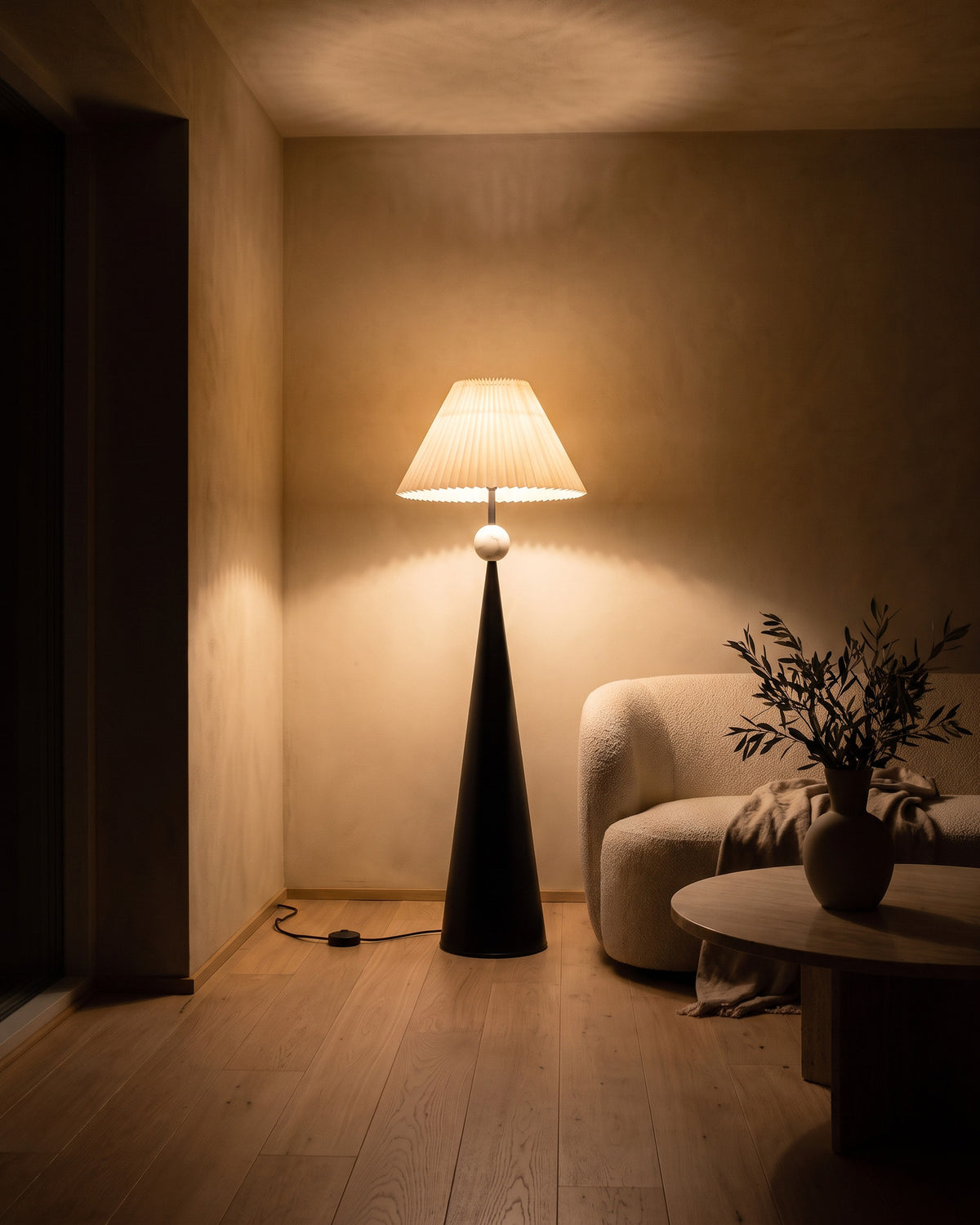 Lampadaire Cône allumé la nuit dans un salon, effet de lumière