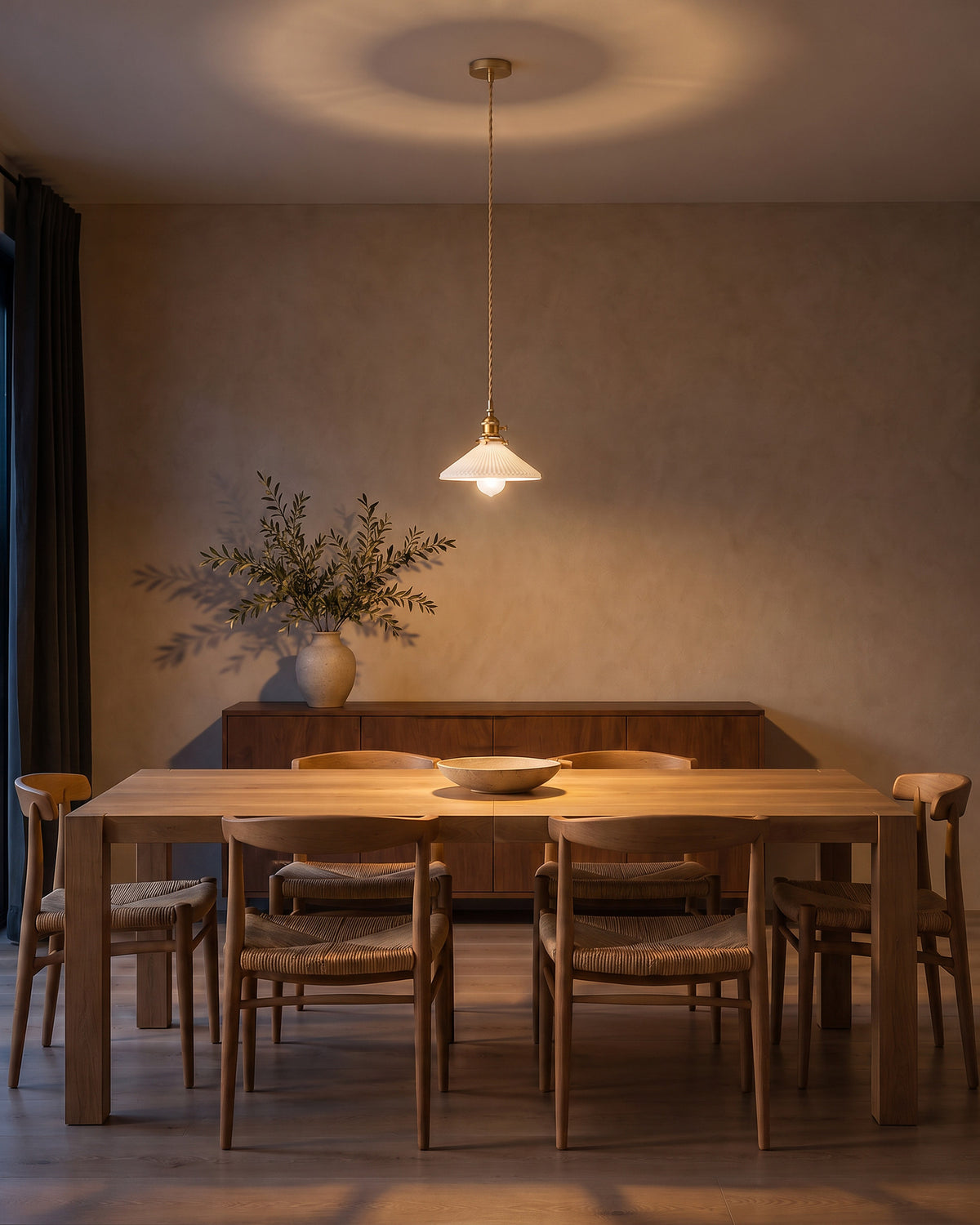 Suspension Corolle allumée la nuit au-dessus d'une table en chêne, salle à manger, effet de lumière