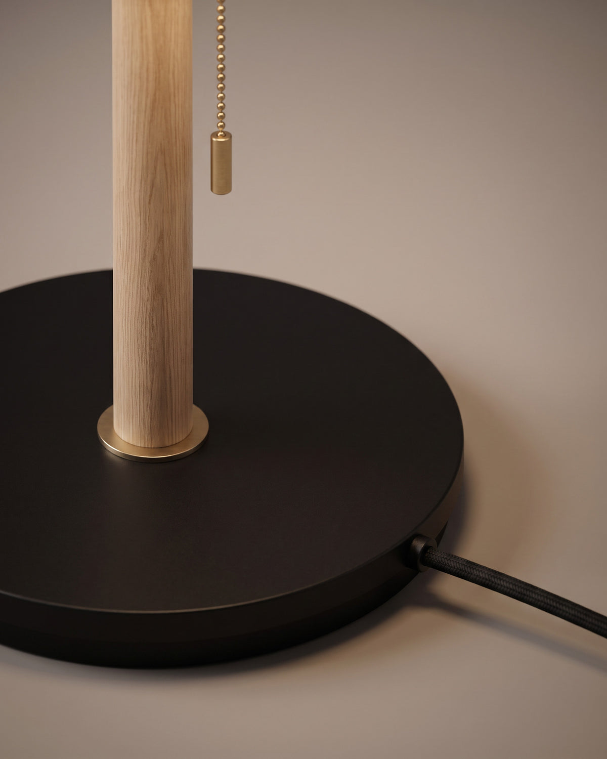 Lampadaire Brume : détail, le socle rond en marbre noir et l'interrupteur au pied sur le câble