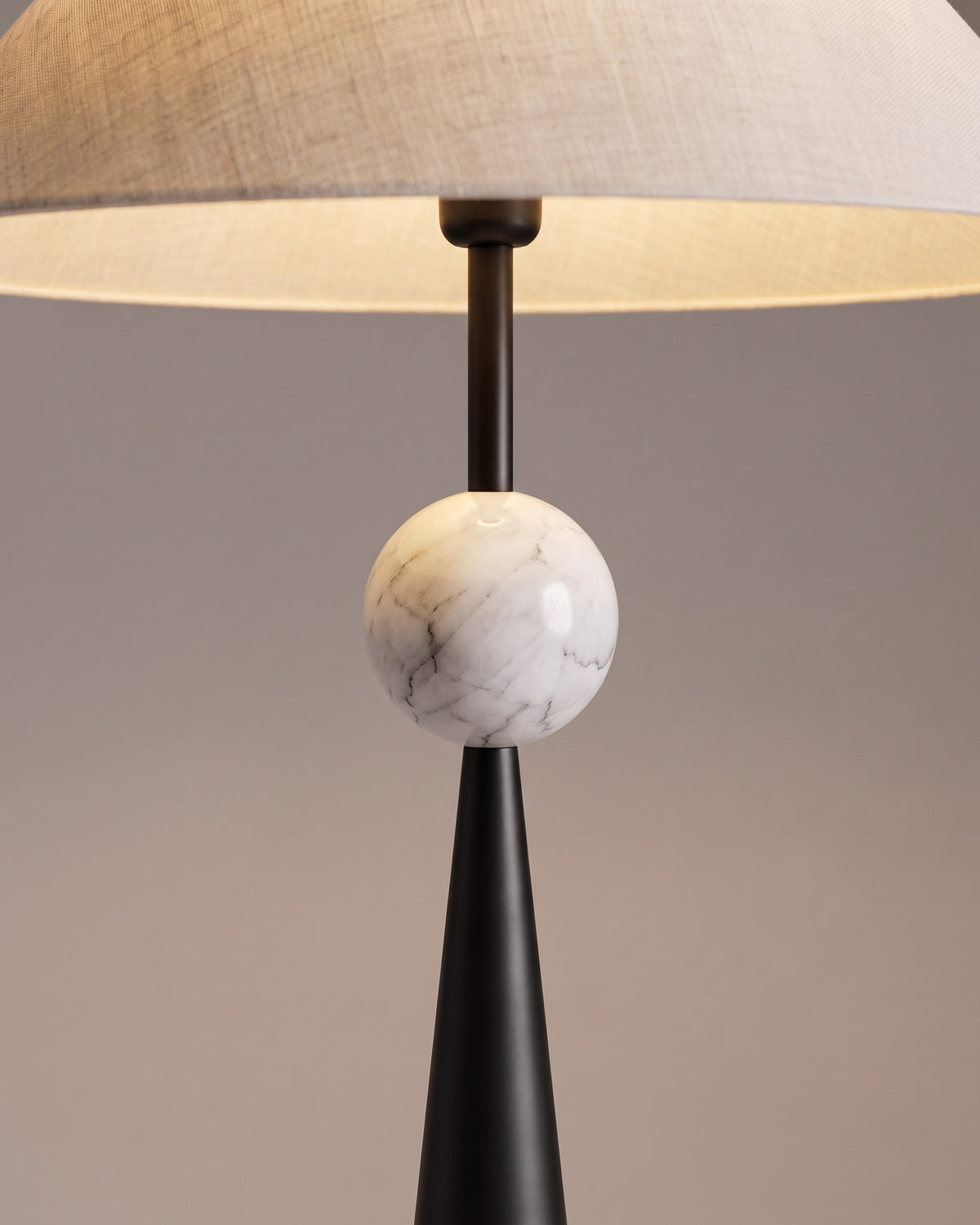 Lampadaire Obélisque, abat-jour plissé et perle dorée : gros plan sur la perle dorée en toupie au sommet du cône et le bas de l'abat-jour plissé