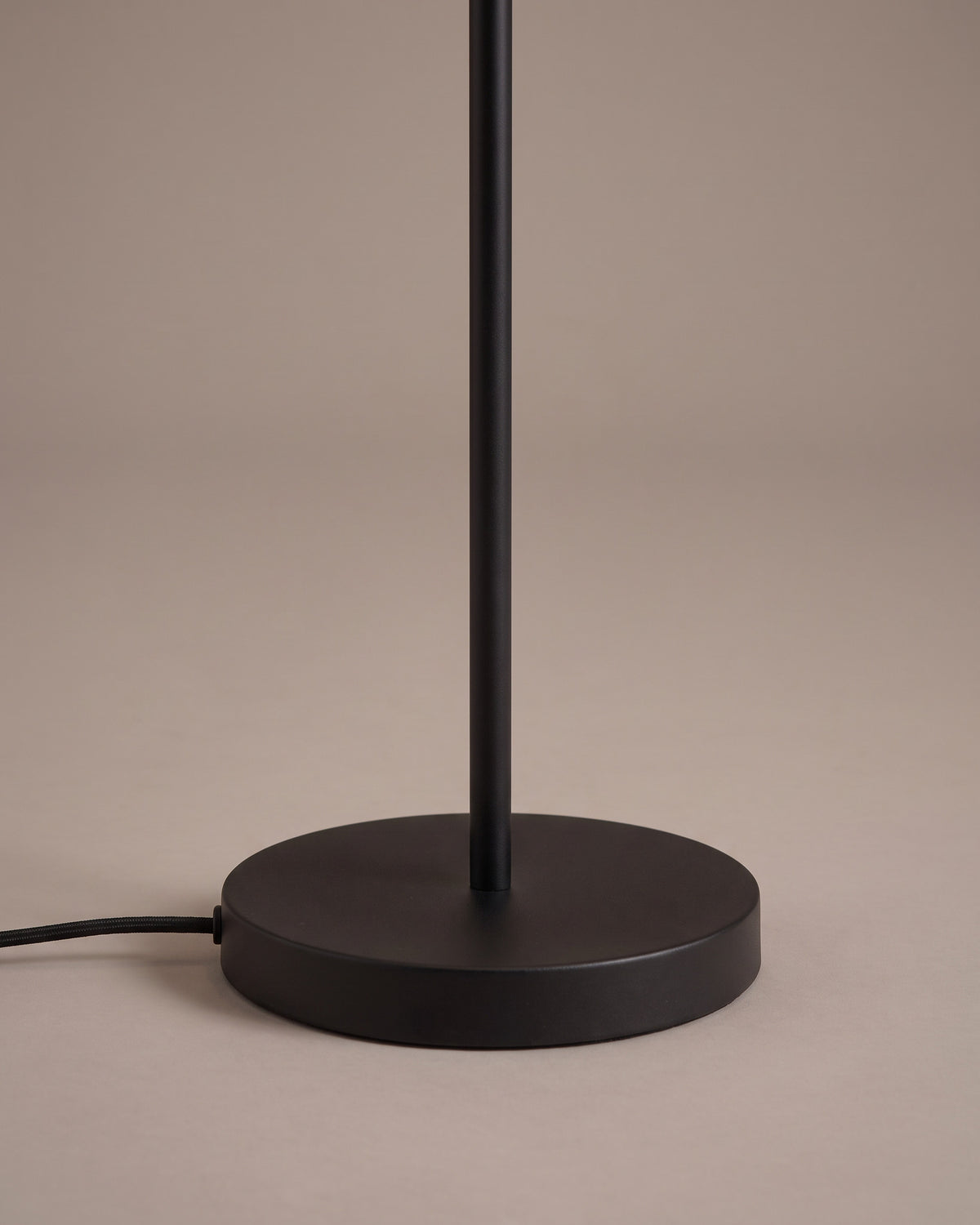 Lampadaire Tandem : détail, le socle rond noir et l'interrupteur au pied sur le câble
