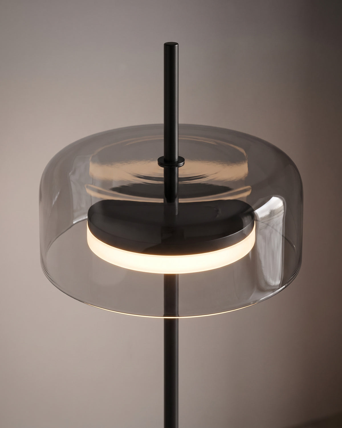 Lampadaire Palet : gros plan sur le diffuseur en verre fumé traversé par la tige dorée et son disque lumineux intérieur