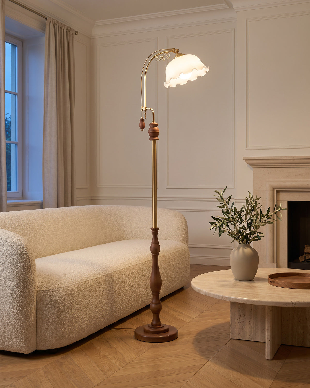 Lampadaire Églantine (tulipe de verre et bras doré) dans une pièce, allumé en soirée