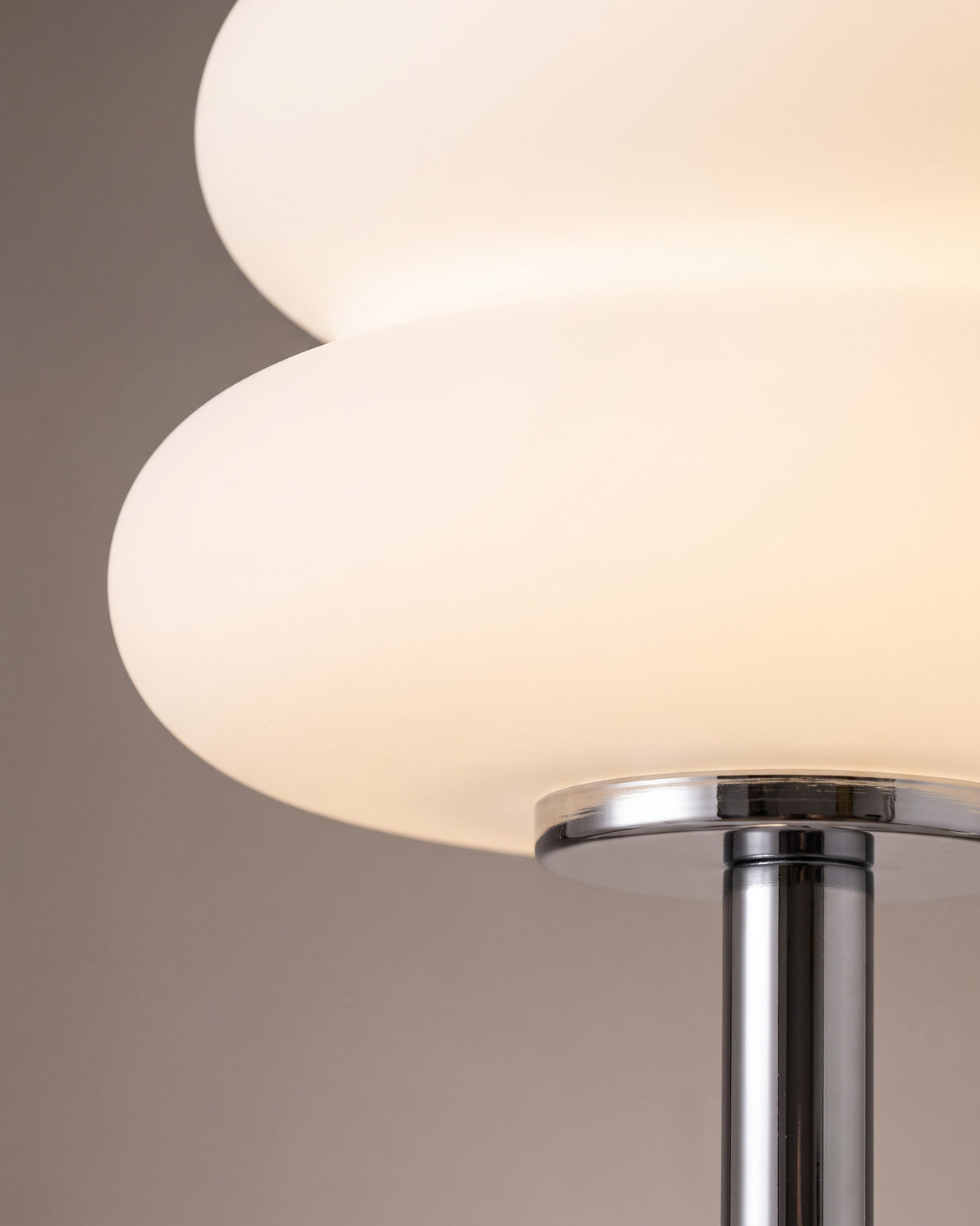 Lampe de table Coussin: gros plan sur la jonction entre le globe opalin à deux étages et la tige chromée