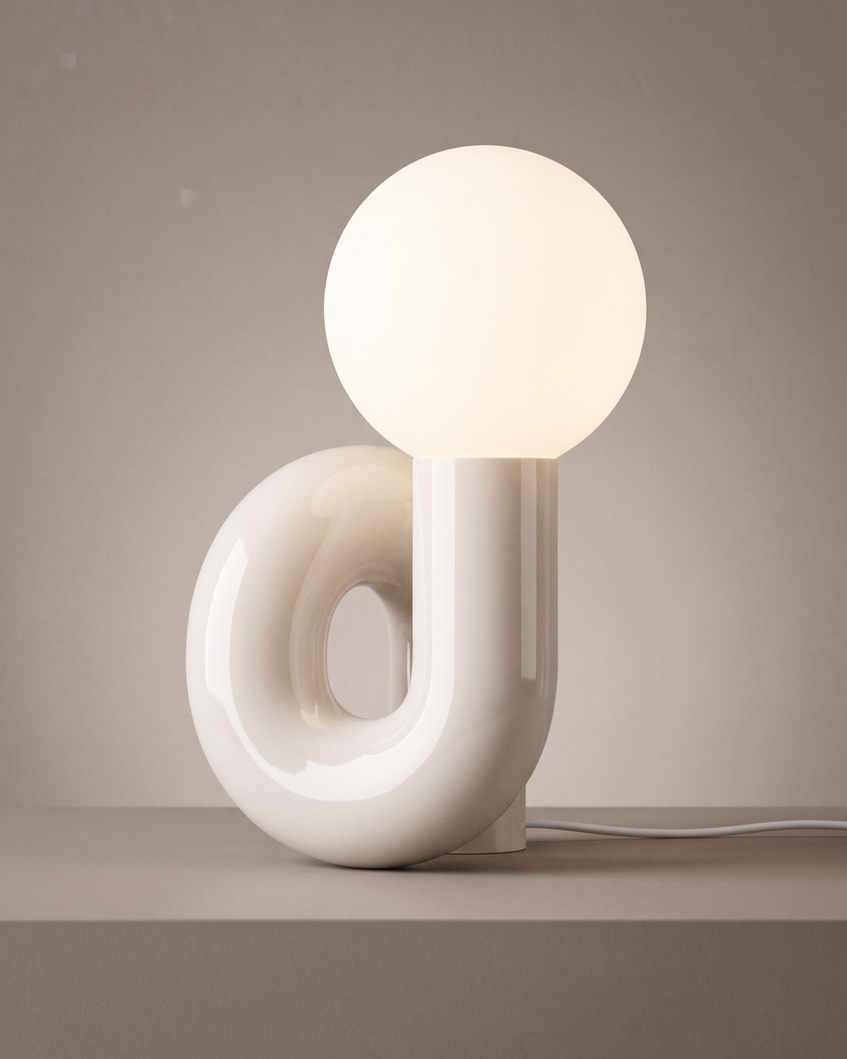 Lampe de table Volute, allumée, photo studio