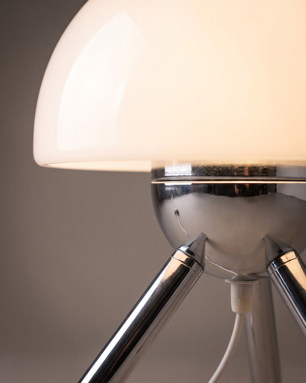 Lampe de table Bolet: gros plan sur la boule chromée qui réunit les trois pieds sous le dôme en verre
