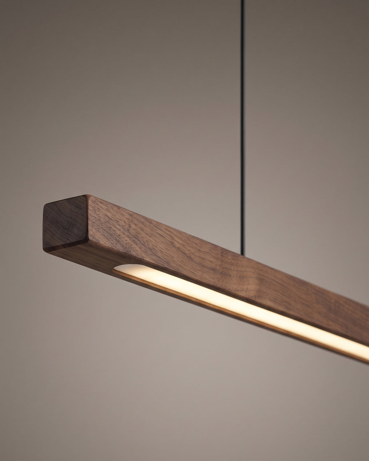 Suspension Ligne : gros plan sur l'extrémité arrondie d'aspect noyer avec la fente lumineuse et l'attache du câble