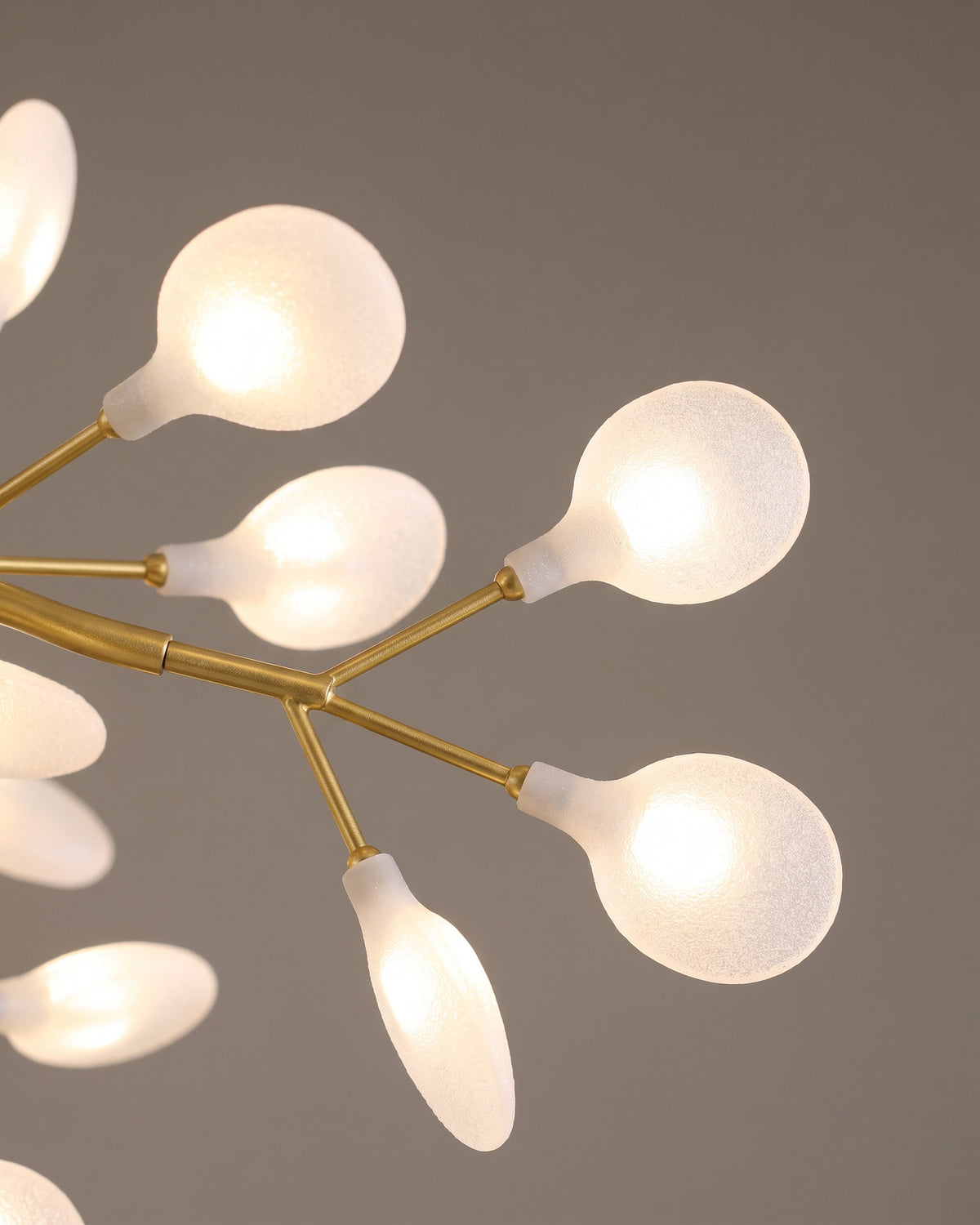 Lustre Lucioles : gros plan sur la matière (branches dorées, pétales givrés)