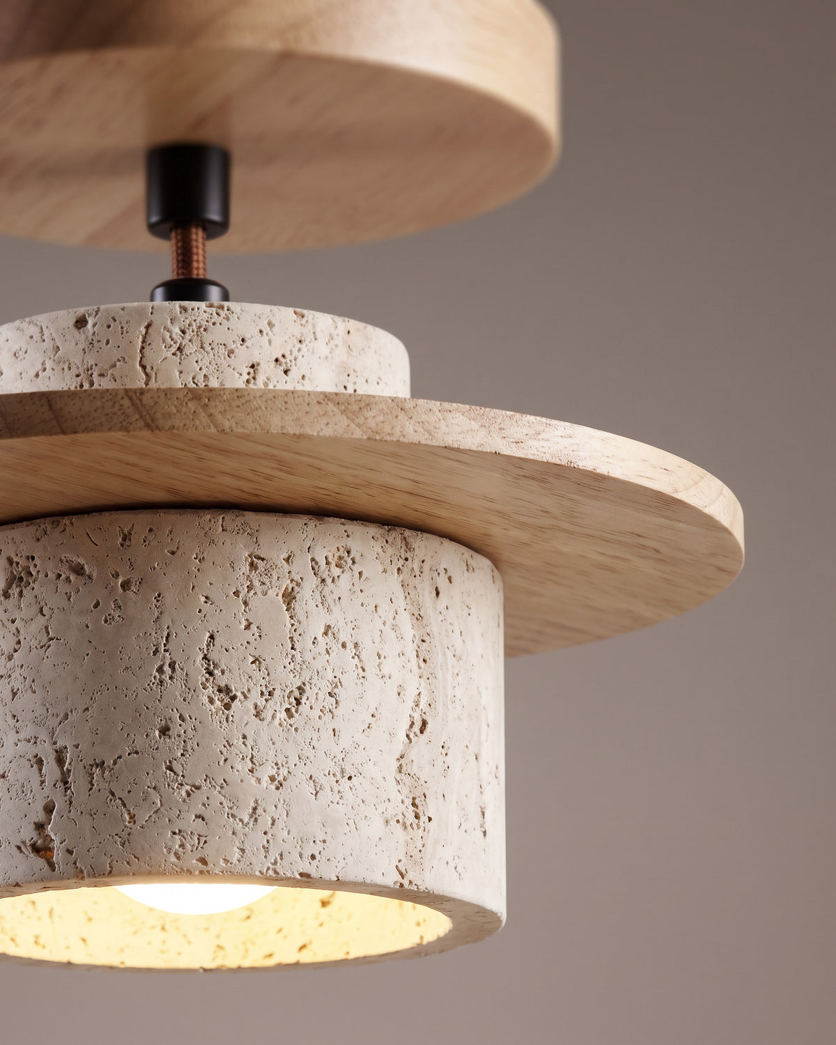 Suspension Soucoupe : gros plan sur la matière (travertin et disque de bois clair)