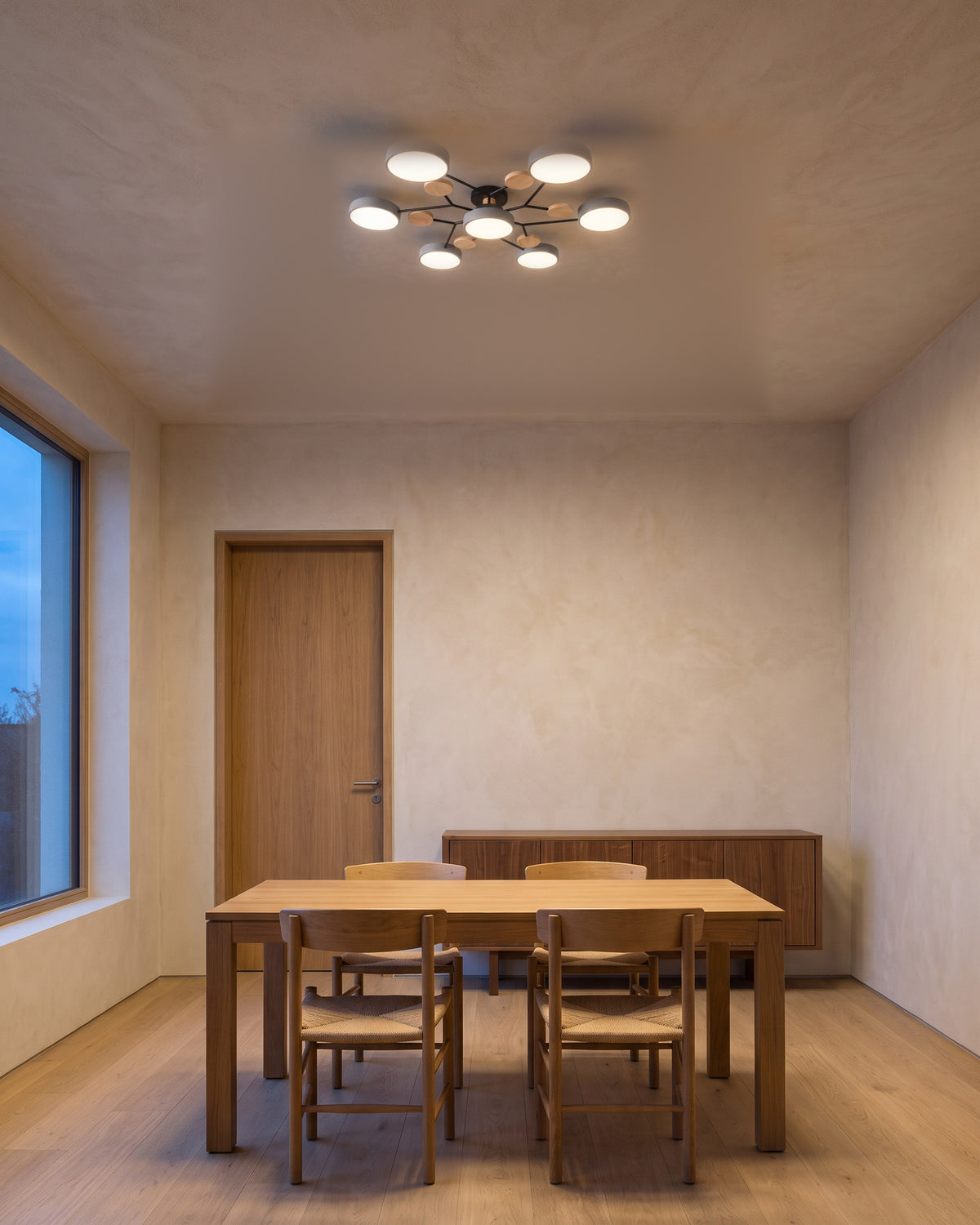 Plafonnier Astre au-dessus d'une table en chêne, salle à manger, vue d'ensemble qui montre sa