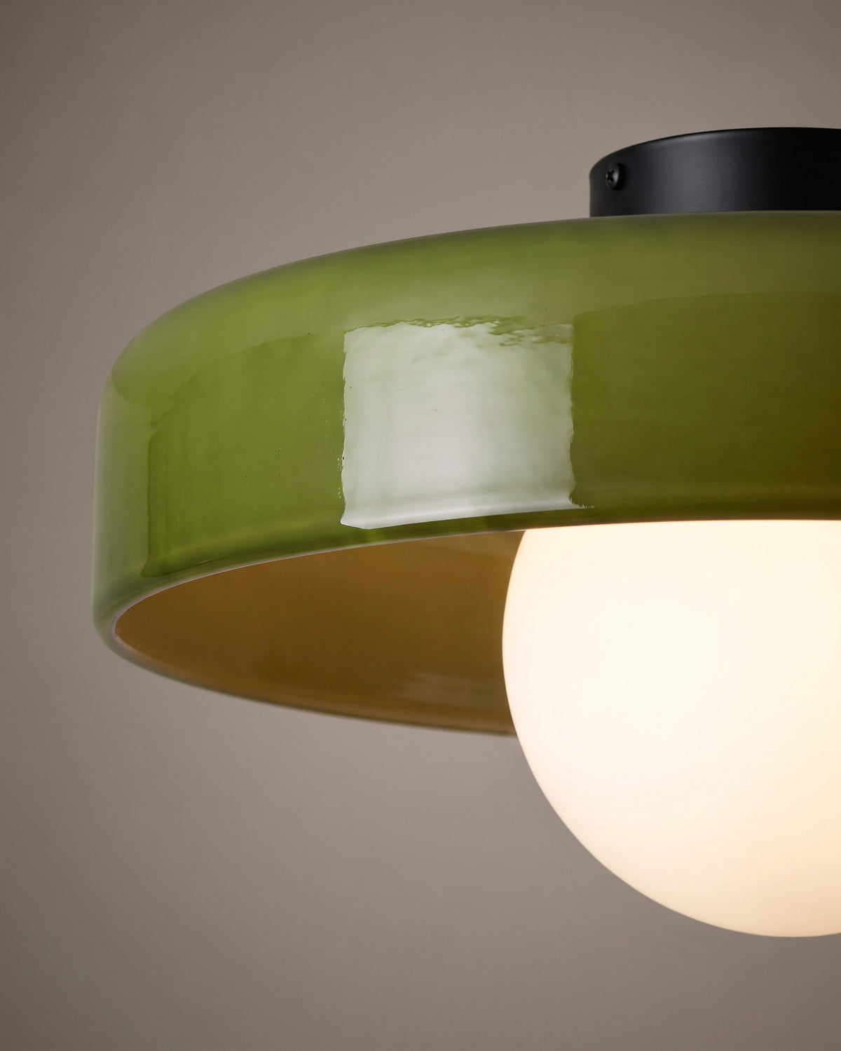 Plafonnier Jade: gros plan sur le bord brillant de la vasque en verre coloré et le globe opale