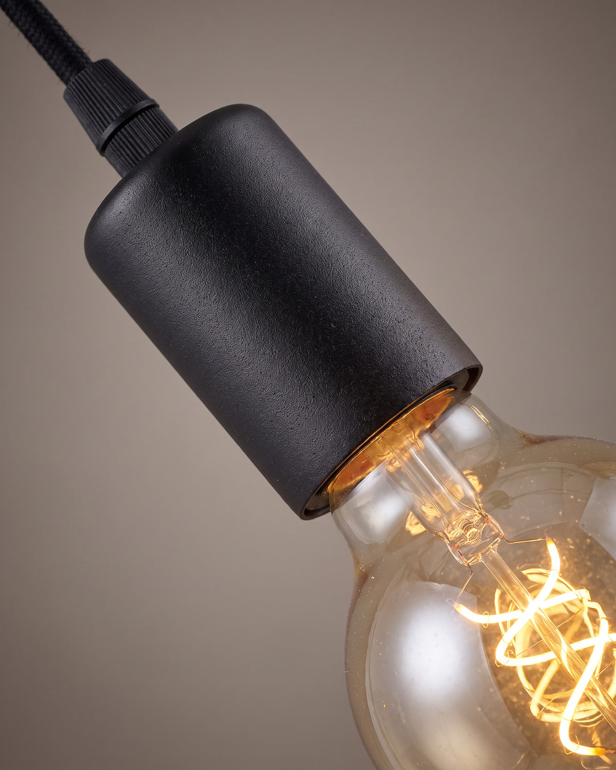 Suspension Chapelet : gros plan sur la matière (trois douilles noires, ampoules apparentes)