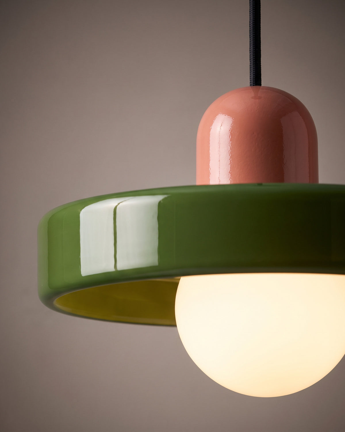 Suspension Émail: gros plan sur le bord brillant du disque en verre et le capuchon coloré