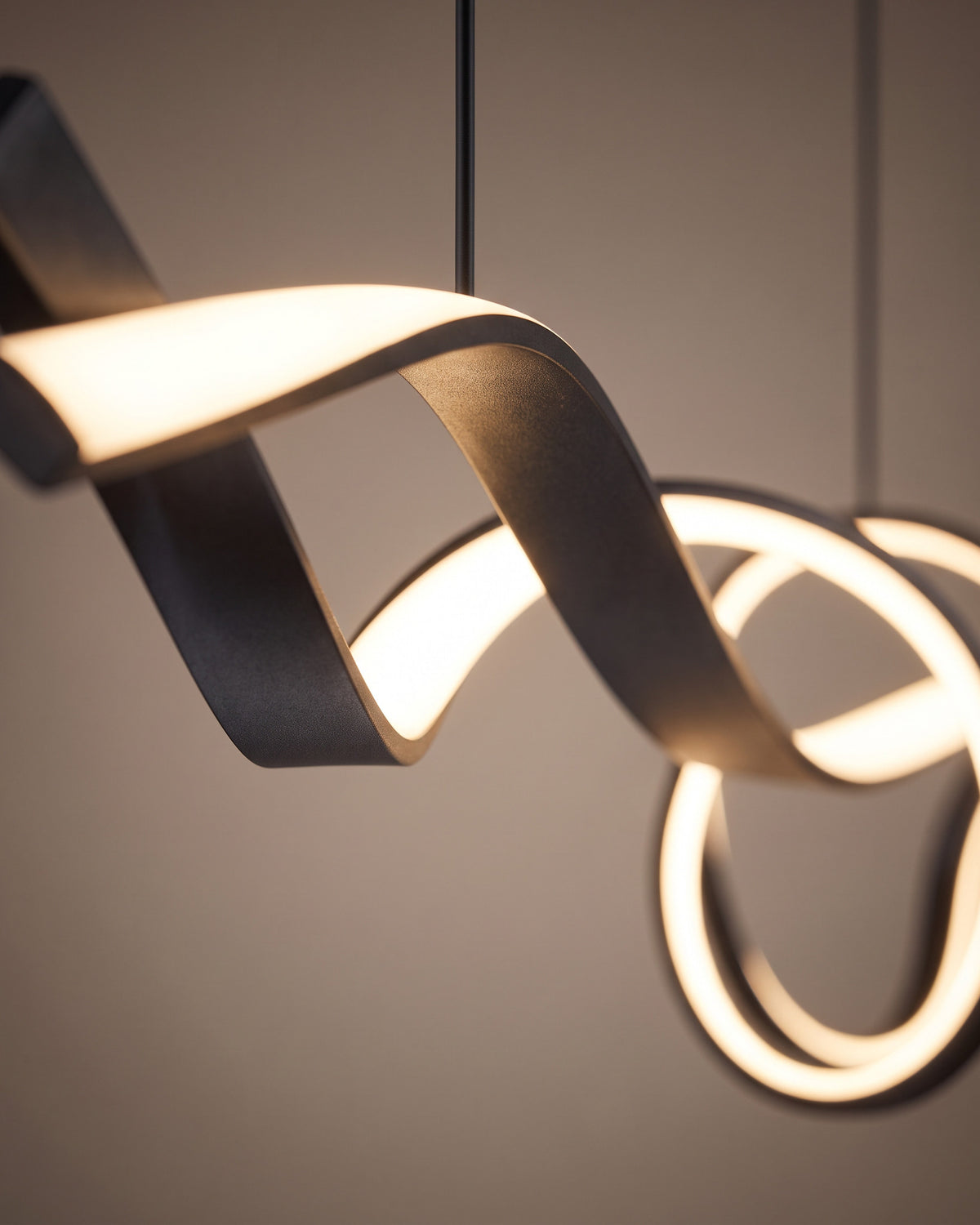 Suspension Houle : gros plan sur la boucle vrillée du ruban noir avec sa bande lumineuse