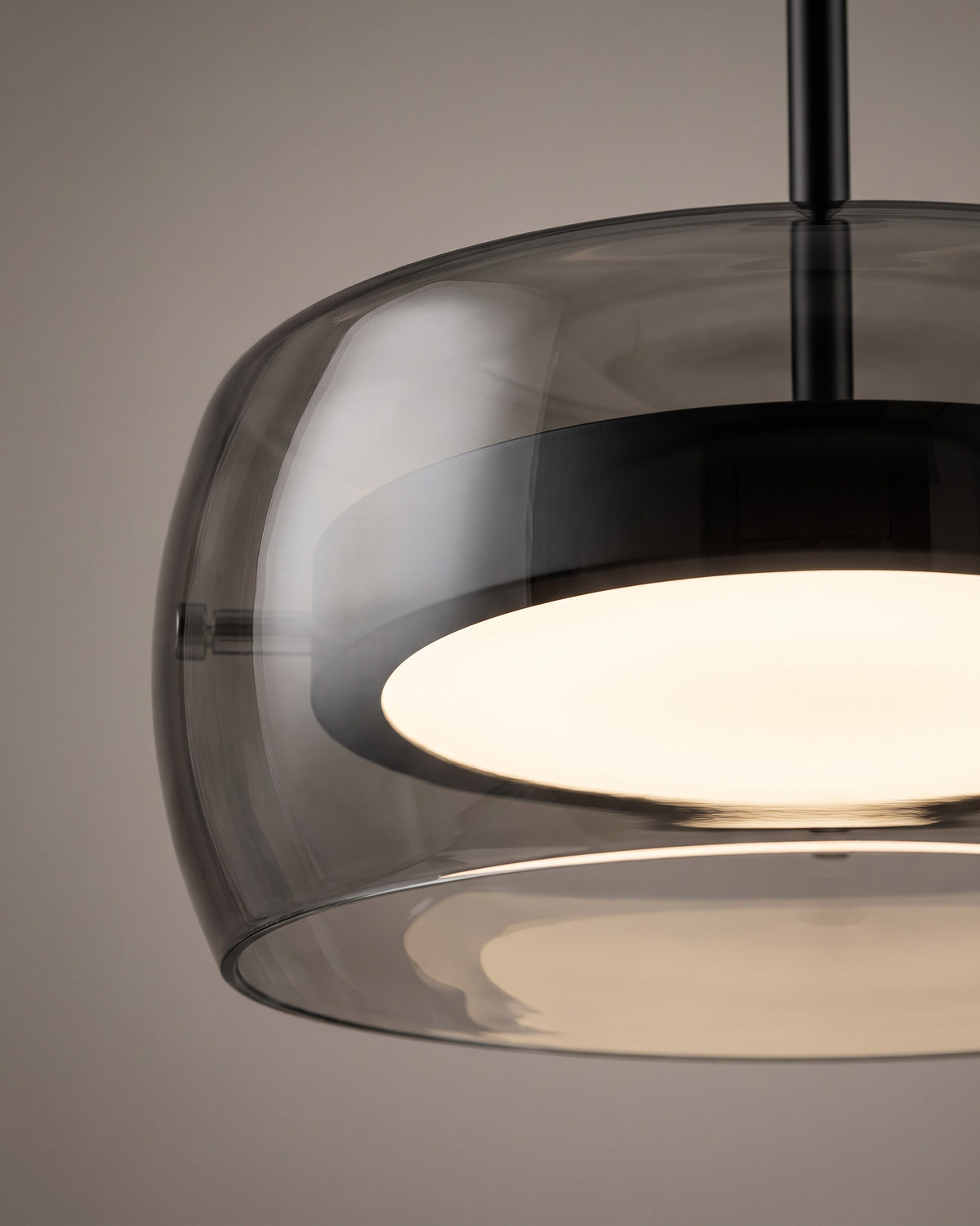 Suspension Fumée : gros plan sur le bord bombé du verre fumé et le disque lumineux à l'intérieur