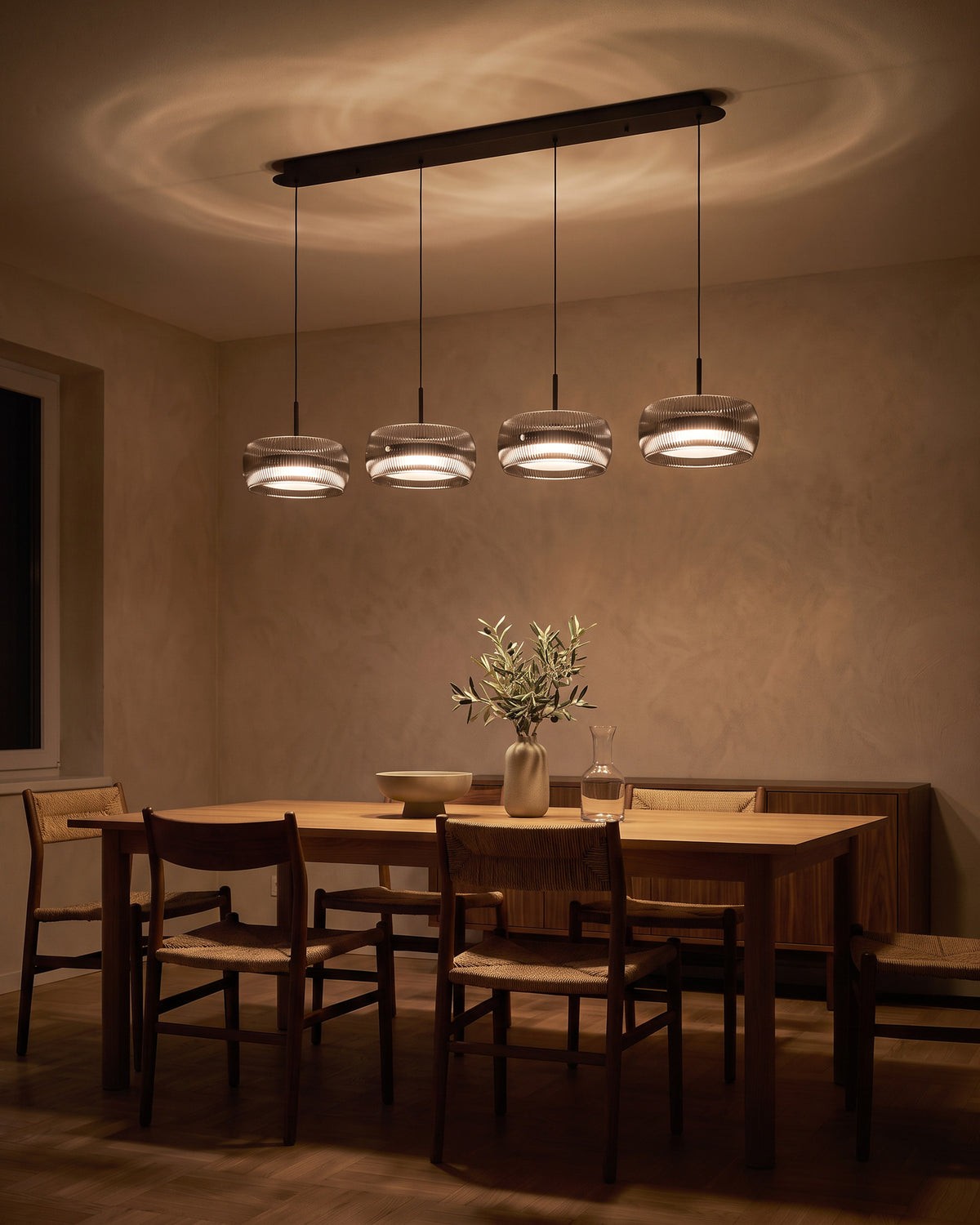 Suspension Quatuor allumée la nuit au-dessus d'une table en chêne, salle à manger, effet de lumière