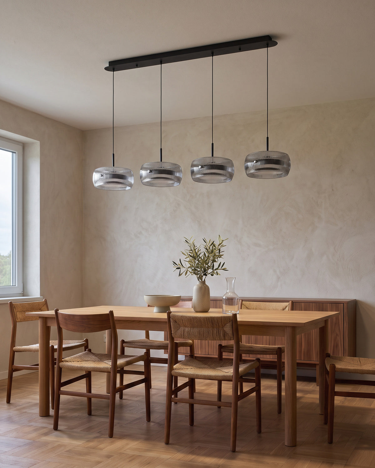 Suspension Quatuor éteinte en journée au-dessus d'une table en chêne, salle à manger