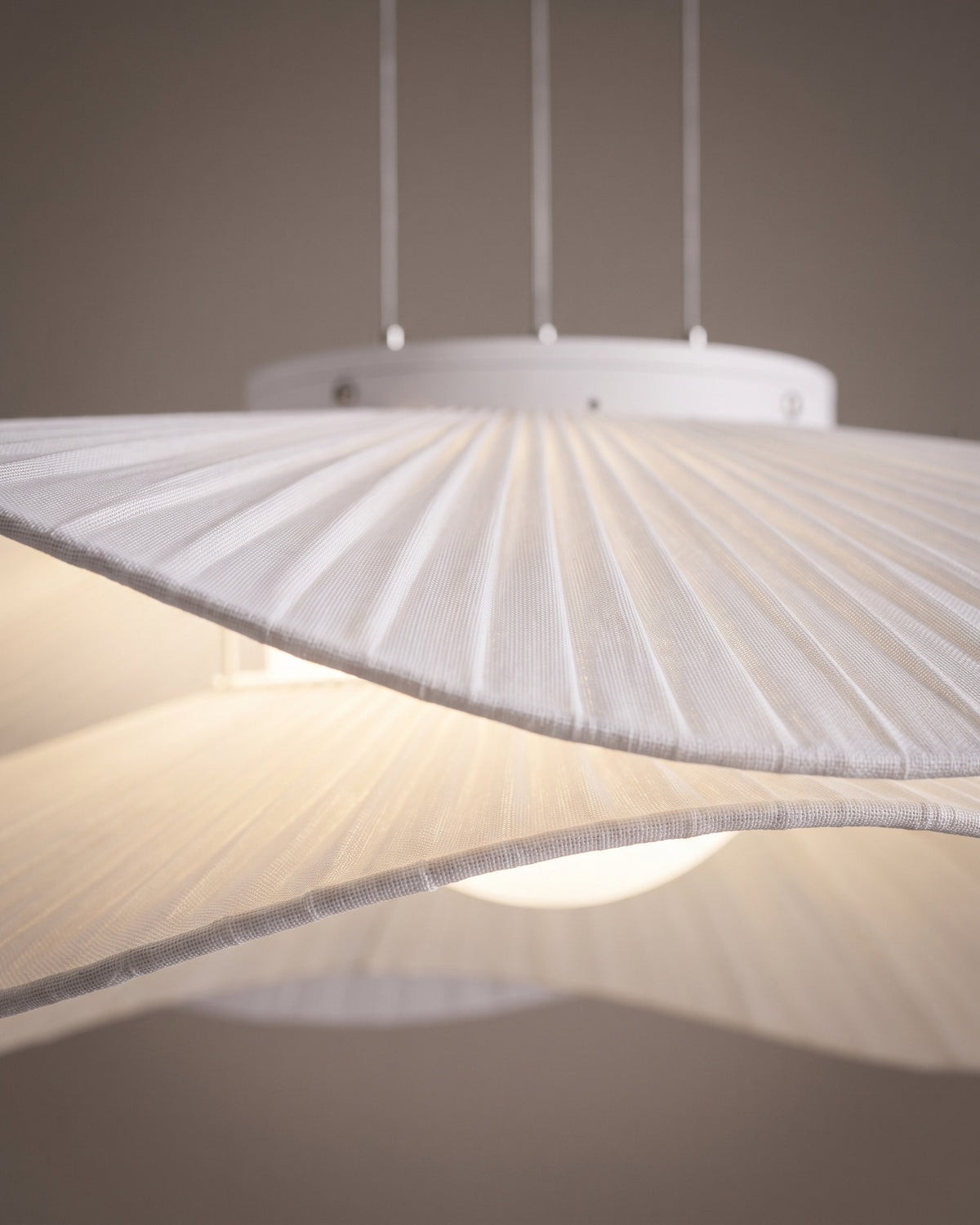 Suspension Nénuphar : gros plan sur les plis rayonnants du tissu blanc près du bord ondulé
